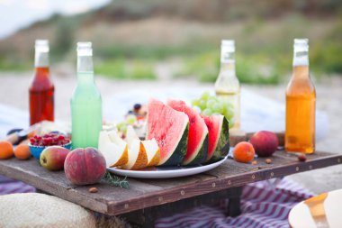 Gün batımında sahilde piknik tarzı boho, yiyecek ve içecek 