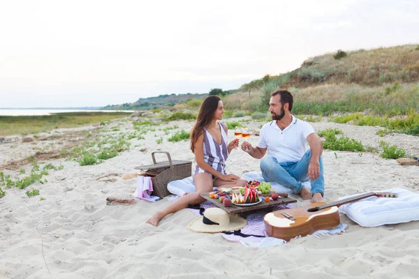 Picknick på stranden vid solnedgången i stil med Boho, mat och dri — Stockfoto