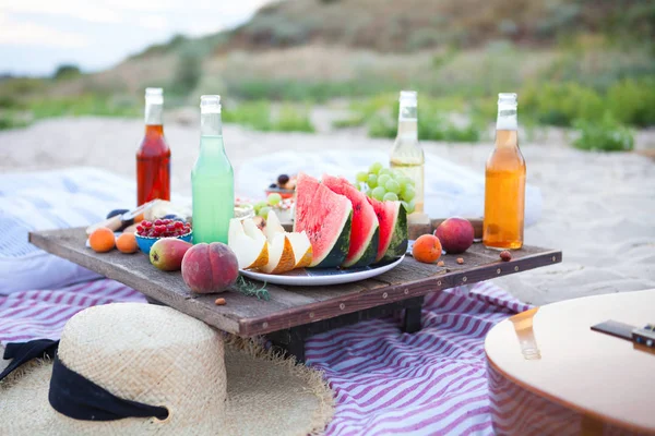 Piknik na plaży o zachodzie słońca w stylu boho, jedzenie i picie — Zdjęcie stockowe