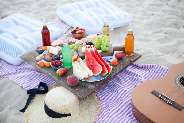Piknik na plaży o zachodzie słońca w stylu boho, jedzenie i picie — Zdjęcie stockowe