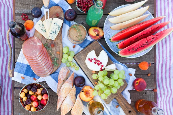 Piquenique na praia ao pôr do sol no estilo boho, comida e bebida — Fotografia de Stock