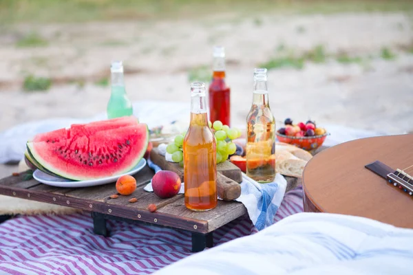 Gün batımında sahilde piknik tarzı boho, yiyecek ve içecek Telifsiz Stok Imajlar