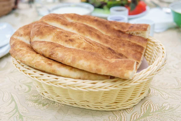 Čerstvý domácí chléb v bílém košíku. Stůl se snídaní. — Stock fotografie