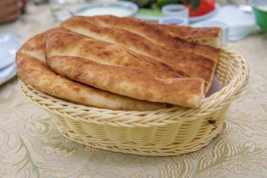 Taze ev yapımı ekmek beyaz sepet içinde. Kahvaltı masası.