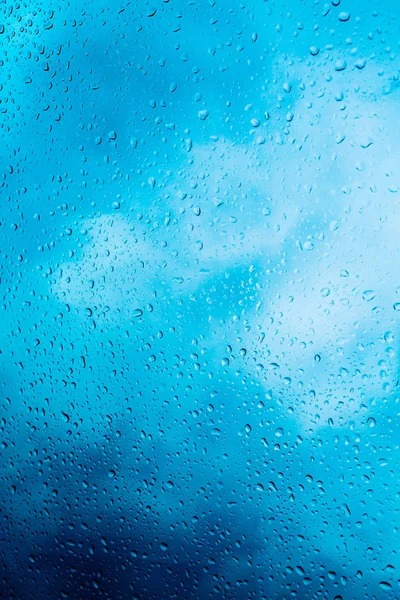 Gotas de chuva no fundo de vidro azul — Fotografia de Stock