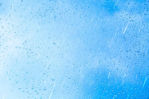 Gotas de lluvia sobre fondo de vidrio azul — Foto de Stock