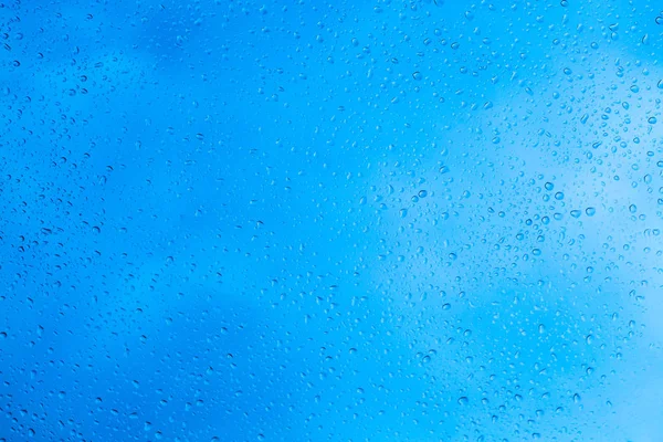 Gotas de chuva no fundo de vidro azul — Fotografia de Stock