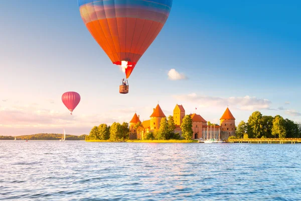 Paisaje con castillo de ladrillo rojo en la isla y globo aéreo volador en Trakai —  Fotos de Stock