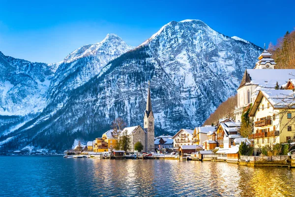 Vista clássica do cartão postal da famosa cidade à beira do lago Hallstatt nos Alpes com o tradicional navio de passageiros em um belo dia ensolarado frio com céu azul e nuvens no inverno, Áustria — Fotografia de Stock