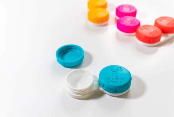 Illustrate different color contact lens cases with lid written replace monthly it is dirty after 30