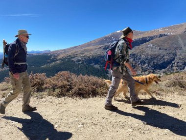 Silverthorne, CO / USA - 1 Ekim 2020: Yaşlılar şapka ve güneş gözlüğü takıyor ve Beyaz Nehir Ulusal Ormanı 'nda sırt çantası ve köpek yürüyüşü yapıyorlar