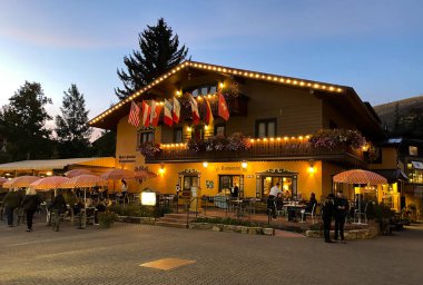 Vail, CO / USA - 28 Eylül 2020: Otel Gasthof Gramshammer 'ın müşterilerle akşam yemeği ve CO' dan geçen turist görüntüsü