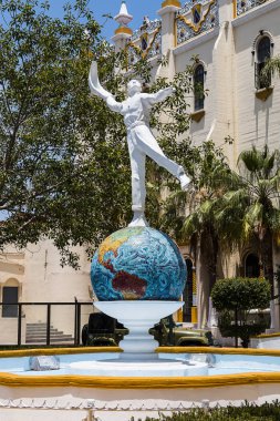 TIJUANA, BAJA CALIFORNIA/MEXICO - JUNE 20, 2018:  A statue of a jai alai player stands in front of El Foro Antiguo Palacio Jai Alai, a former sports arena and historic landmark in the downtown area.  clipart