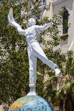 TIJUANA, BAJA CALIFORNIA/MEXICO - JUNE 20, 2018:  A statue of a jai alai player in front of El Foro Antiguo Palacio Jai Alai. This former sports arena is currently used as an entertainment venue. clipart