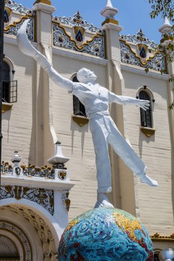 TIJUANA, BAJA CALIFORNIA/MEXICO - JUNE 20, 2018:  A statue of a jai alai player in front of El Foro Antiguo Palacio Jai Alai, a historic landmark and former sports arena in the downtown area. clipart