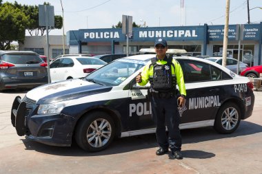 Tijuana, Baja California'deki/Meksika - 20 Haziran 2018: Bir polis memuru başparmak-up bir polis karakolu önünde şehir merkezinde verir..