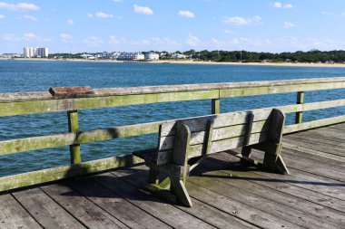 Norfolk, Virginia Ocean View balıkçı iskelesinde bir bank, arka planda Ocean View Beach kıyı şeridi ile.