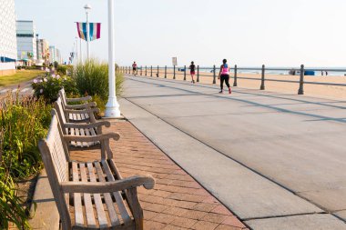 Virginia Beach, Virginia/Usa - 13 Temmuz 2017: Bir sıra bank, insanların yakınlarda egzersiz yaptığı popüler kaldırıma bak. 