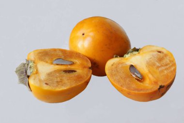 bahçede yetiştirilen beyaz bir arka plan üzerinde olgunlaşmış Trabzon hurması