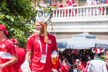 Moskova, Rusya - 26 Haziran 2018: 2018 Dünya Kupası. Danimarka taraftarları kırmızı t-shirt ve şapka boynuzları ve Manezhnaya kare yapışkanlık dışarı dil ile