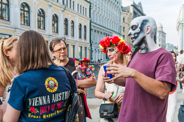 MOSCOW, RUSSIA - June 29, 2018: The 2018 FIFA World Cup. A National Mexican  Celebration of the Day of the Dead. Bald man disguised as a skeleton and a girl dressed as the goddess of death