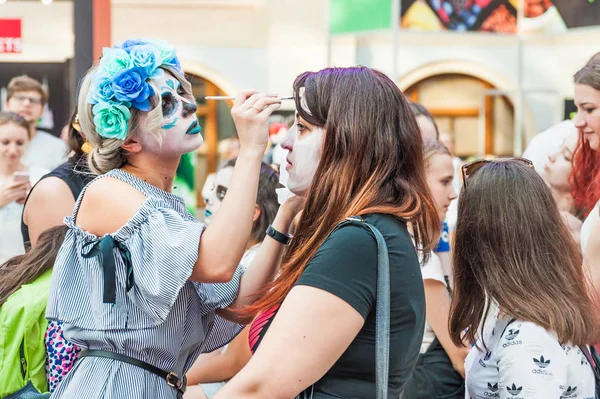 Moskova, Rusya - 29 Haziran 2018: 2018 Dünya Kupası. Mexican fanlar Gostiny Dvor için ulusal bir ev. Ölülerin günü kutlaması. Kız makyaj için başka bir kızın yüz boyama işi ile