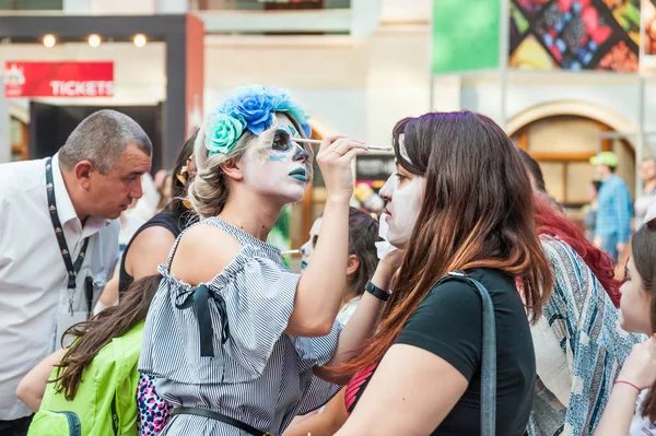 Moskova, Rusya - 29 Haziran 2018: 2018 Dünya Kupası. Mexican fanlar Gostiny Dvor için ulusal bir ev. Ölülerin günü kutlaması. Kız makyaj için başka bir kızın yüz boyama işi ile