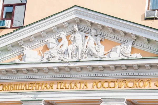 Fragment of architecture of the Chamber of Commerce and Industry of the Russian Federation. Pediment with high relief. The former building of the Moscow exchange, 1875