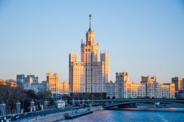 Stalin gökdelen Moskova Nehri Kotelnicheskaya setin içinde batan güneşin ışınları üzerinde görüntüleyin. Kış cityscape
