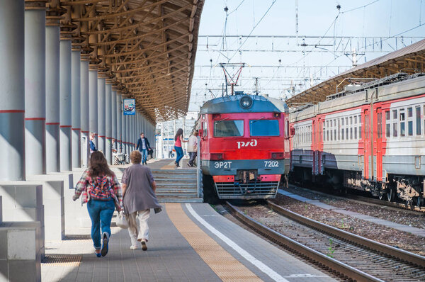 МОСКВА, РОССИЯ - 3 августа 2015 года: Пригородный электропоезд под посадкой Киевского железнодорожного вокзала (Киевский вокзал). Люди опаздывают и бегут к поезду
