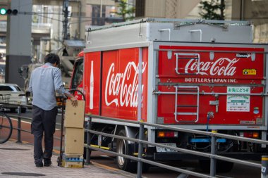 Tokyo, Japonya, 4 Kasım 2023: Coca-Cola dağıtım kamyonu ve şehir ortamında çalışan işçi
