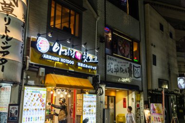 Tokyo, Japonya, 4 Kasım 2023: Kalabalık bir Tokyo caddesinin yerel yemek ve neon tabelaları ile gece manzarası