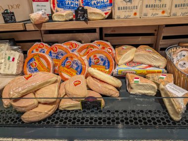 France, March 2 2024: Assorted Cheeses on Supermarket Shelf clipart