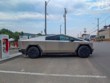 Kanada, 28 Temmuz 2025: Bulutlu mavi gökyüzü gününde istasyonda fütürist elektrik kamyonu şarj ediliyor