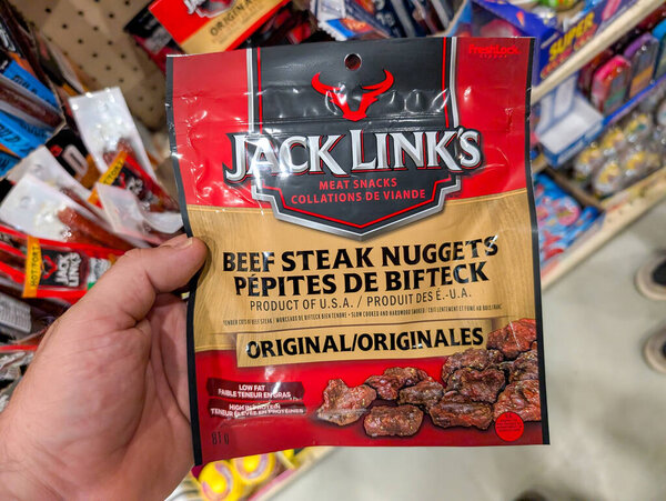 Canada, 20 July 2025 : Hand Holding Jack Links Beef Steak Nuggets Original Meat Snack Package