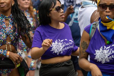 Quebec, Kanada, 05 Temmuz 2025: Aynı mor temalı giysileri giyen bir grup kadın sokak karnavalını kutluyor