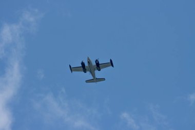 Kanada, 11 Ağustos 2025: Mavi gökyüzü ve bulutlarla yukarıda uçan çift motorlu uçak