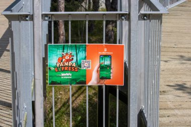 Kanada, 09 Ağustos 2025: Panda Express oyun tabelası ormanlık arka planda metal çitlere asıldı