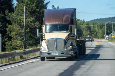 Kanada, 14 Ağustos 2025: Büyük bir kamyonet kırsal manzaralı ağaç sıralı otoyolda ilerliyor