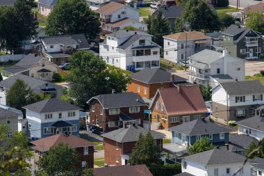 Quebec, Kanada, 18 Temmuz 2025: Ağaçları, sokakları, çatıları ve görülebilir yardaları olan banliyö evleri yığını