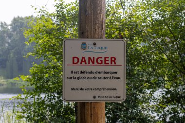 Kanada, 26 Temmuz 2025: Tehlike uyarısı işareti La Tuque nehri yakınlarındaki ağaçlarla çevrili