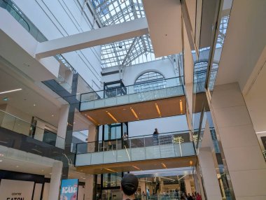 Quebec, Kanada, 07 Temmuz 2025: Modern alışveriş merkezi cam tavanı, birden fazla seviye, insanlar, mimari simetri.