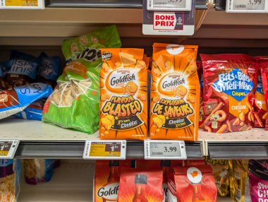 Quebec, Kanada, 04 Temmuz 2025: Japon balığı çedar krakerleri ve ürün fiyat etiketlerinin yer aldığı abur cubur reyonu