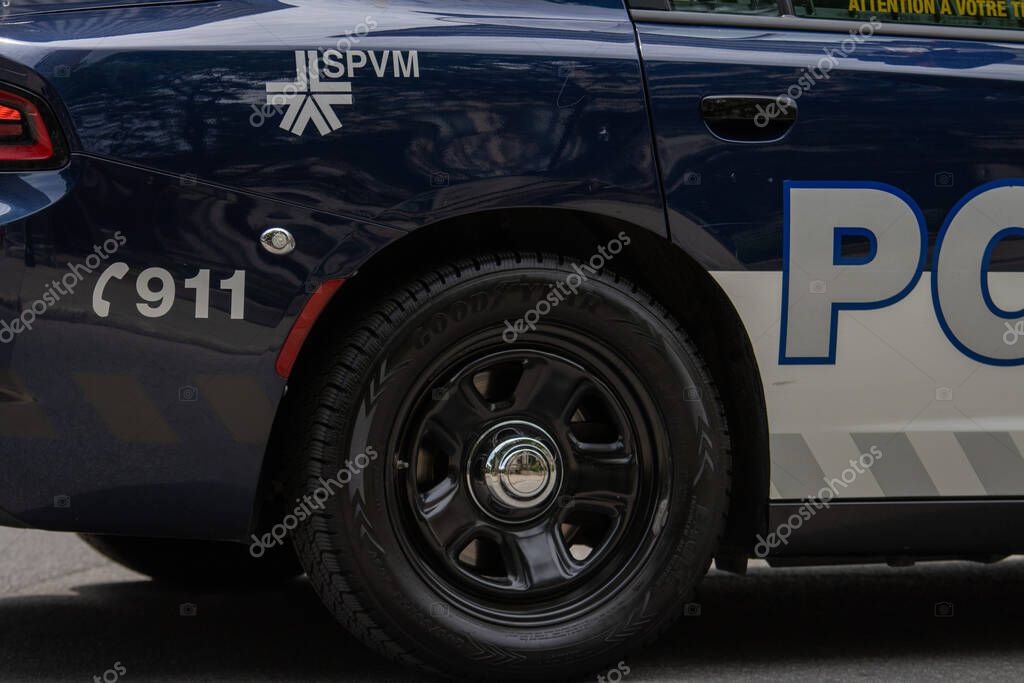Canada, 05 July 2025 : Police vehicle rear wheel SPVM emergency number visible urban street scene