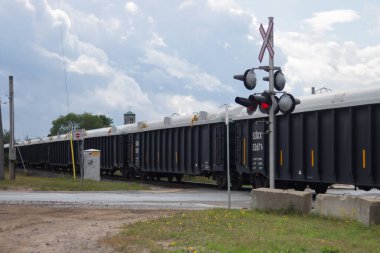 Kanada, 07 Eylül 2025: Uzun yük treni bulutlu ve dramatik gökyüzü manzarası altında tren geçişi