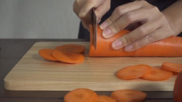 慢动作 关闭在厨房的砧板上的女人做健康的食物和切胡萝卜 — 图库视频影像