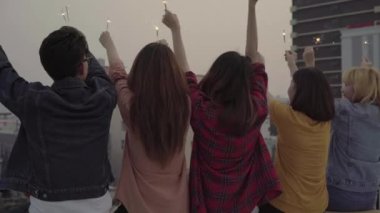 Açık atış gençlerin çatı partisi. Asya arkadaşlar mutlu grup zevk ve maytap çatı üst partide akşam günbatımında oynamak. Tatil kutlaması festival partisi. Genç Yaşam parti.