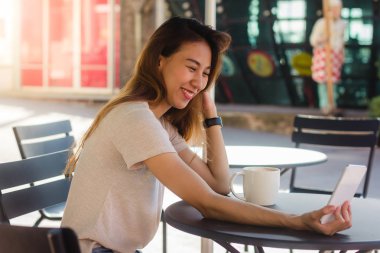 Café'de bir akıllı telefon kullanarak bir selfie alarak çekici güzel mutlu genç Asyalı kadın. Genç Asyalı kız kendi kendine portre alarak restoranda.
