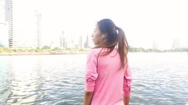 Yavaş hareket - Asyalı güzel kadın fitness kıyafetler içinde kullanıyorsanız bir smartwatch müzik, dinlemek için parkta çalıştırdıktan sonra Evet. Çekici kadın koşu. 