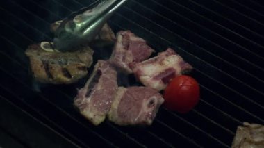 Pişmemiş et parçası metal forseps kullanarak altında ateşle sıcak sigara ızgarada pişirme Şef koyar, ağır çekim kadar yakın.